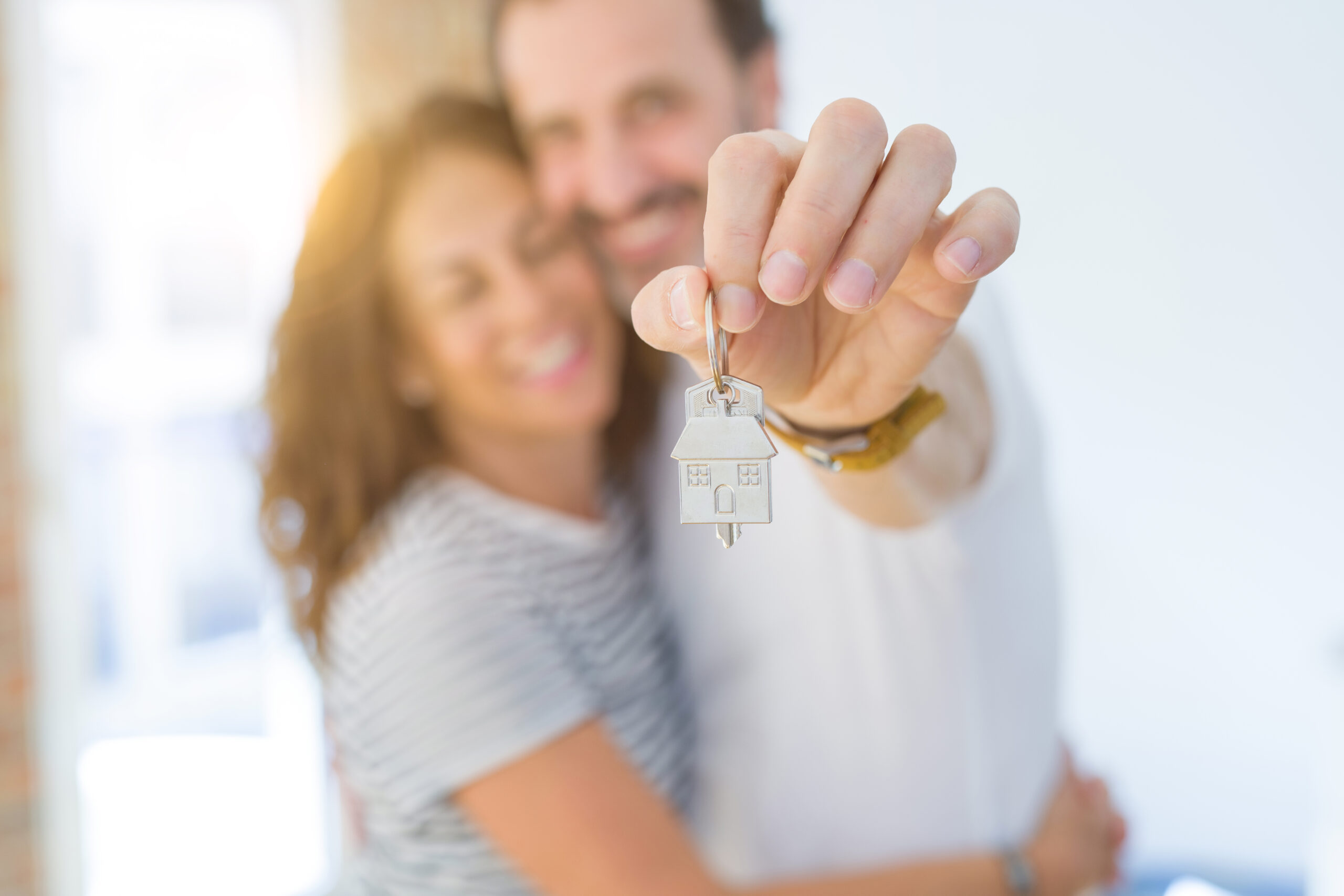 Mature couple holding the keys to their new home, ready to move in